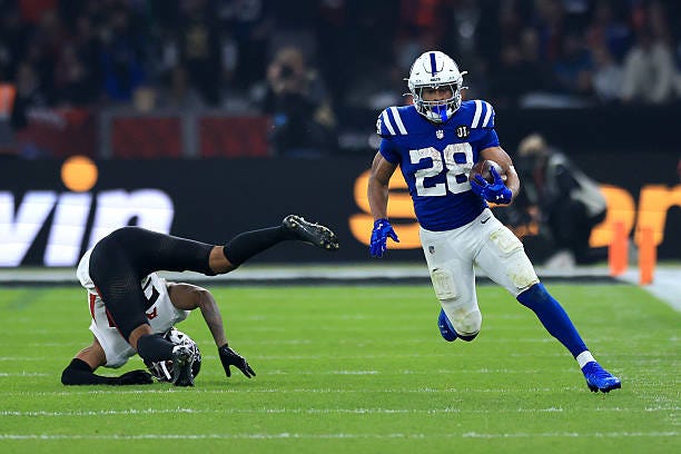 Terrell of Atlanta Falcons falls to the floor as Jonathan Taylor of Indianapolis Colts runs with the ball before scoring a touchdown uring the NFL...