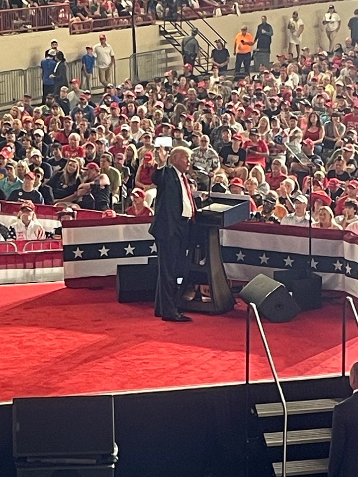 A photo of Mark & Kelly in front of their motorhome that matches ours, one with Tommy, Kelly & me playing games, my photo of Trump on stage at the Harrisburg rally and my commemorative button.