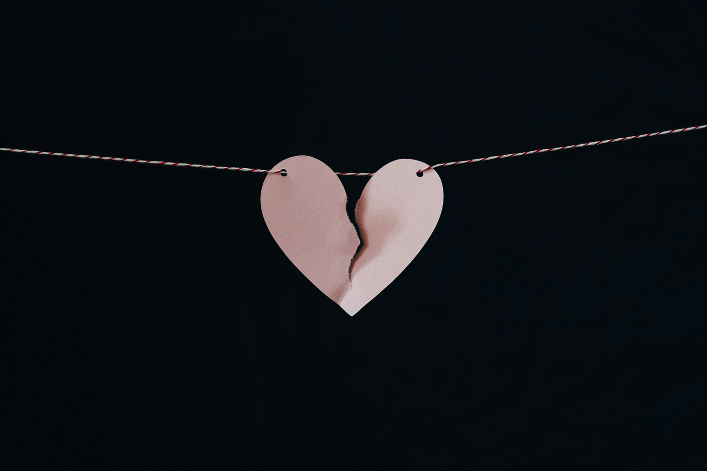 paper heart ripped in two hanging on a string