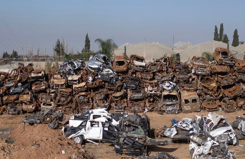 Dozens of destroyed cars and vans sitting in an open lot Dozens of destroyed cars and vans sitting in an open lot
