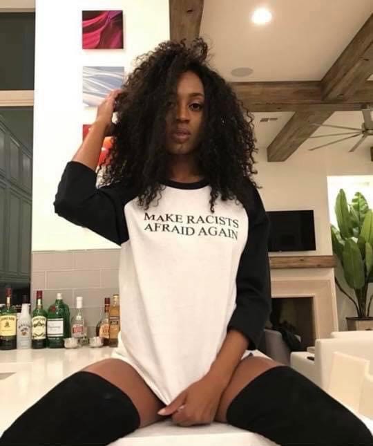 A woman wears a protest shirt: "Make Racists Afraid Again"