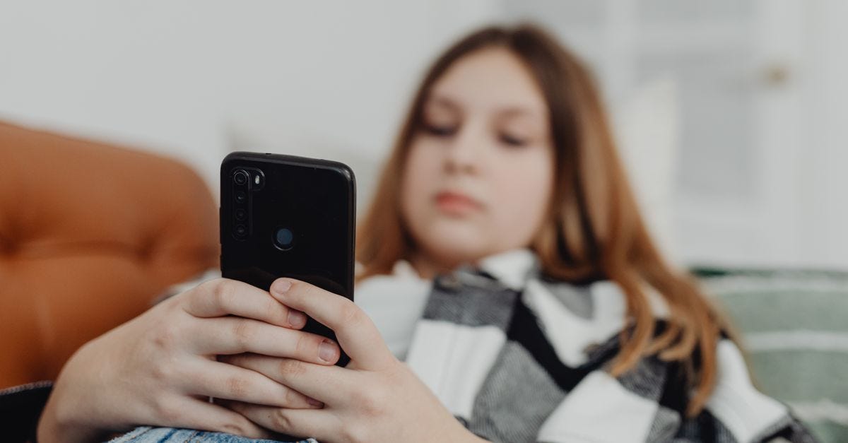 Photo: www.kaboompics.com / Pexels Teenage girl using smartphone while relaxing on a sofa, depicting leisure and connectivity.