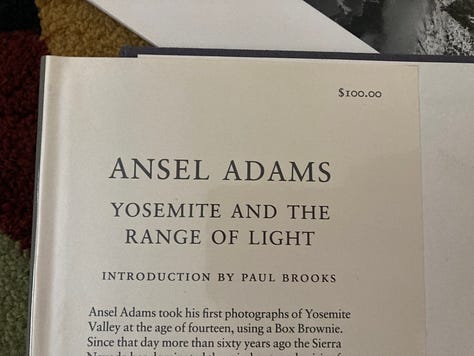A small collection of Ansel Adams calendars and the book "Yosemite and The Range of Light"