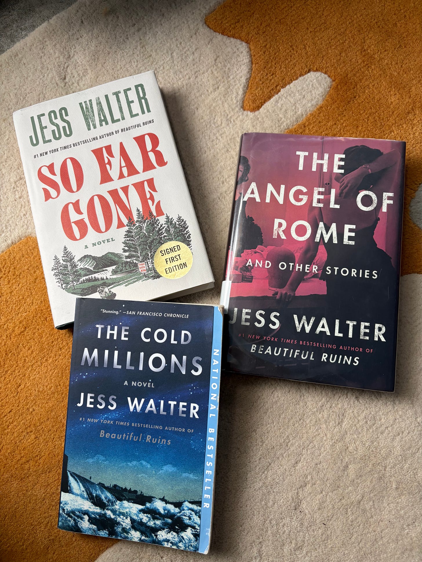 three books by Jess Walter laid out on carpet