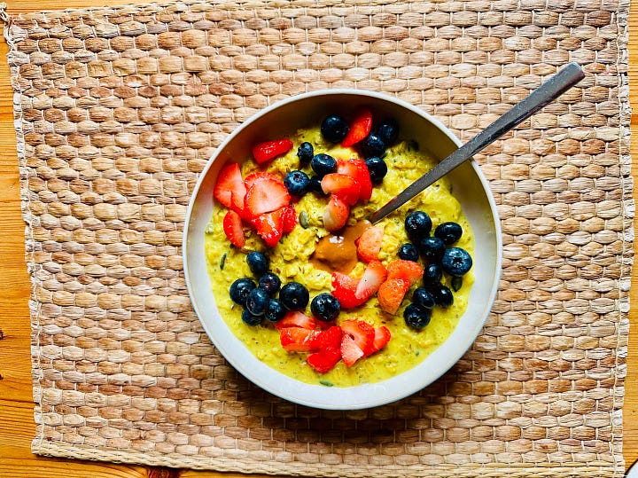 Turmeric porridge with seeds and berries next to eggs and avocado—protein-first autumn breakfast for stable glucose.