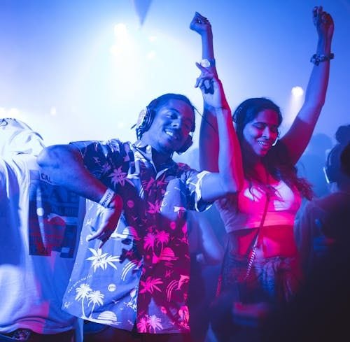 Free Vibrant nightclub scene with people dancing energetically to music. Stock Photo