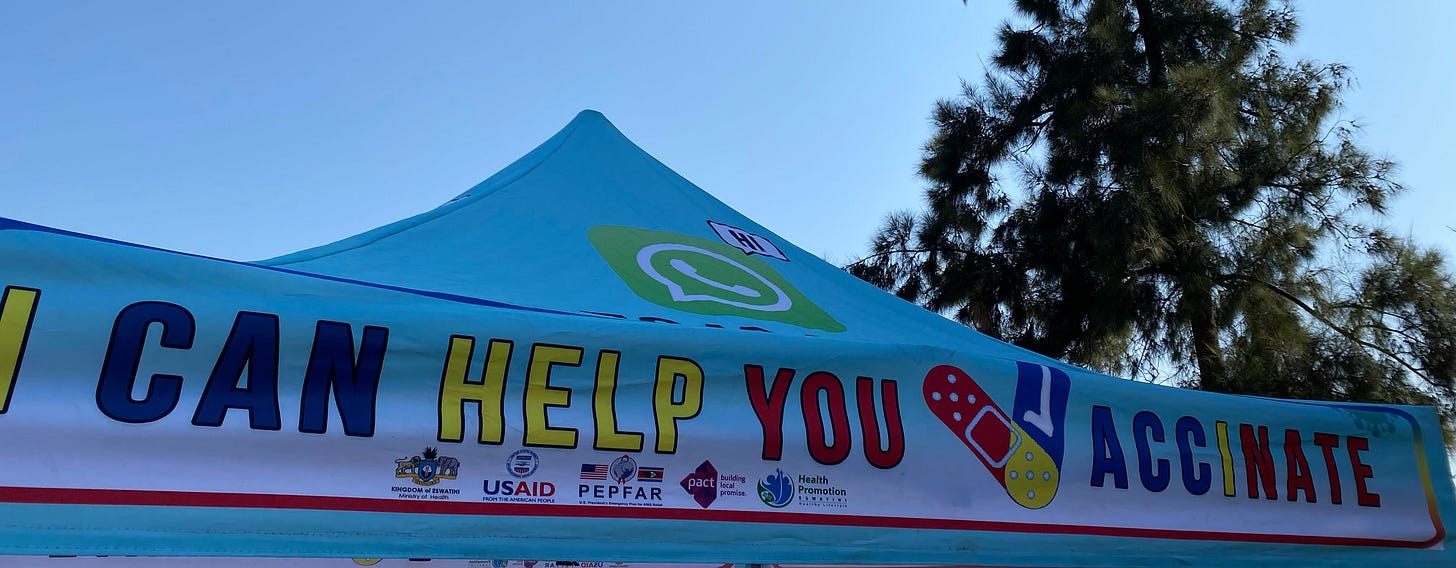 A tent in Eswatini reads, “I can help you vaccinate” during the deployment of COVID-19 vaccines in Eswatini. Logos of the Ministry of Health of Eswatini, USAID, PEPFAR, Pact, and Health Promotion Eswatini are visible.