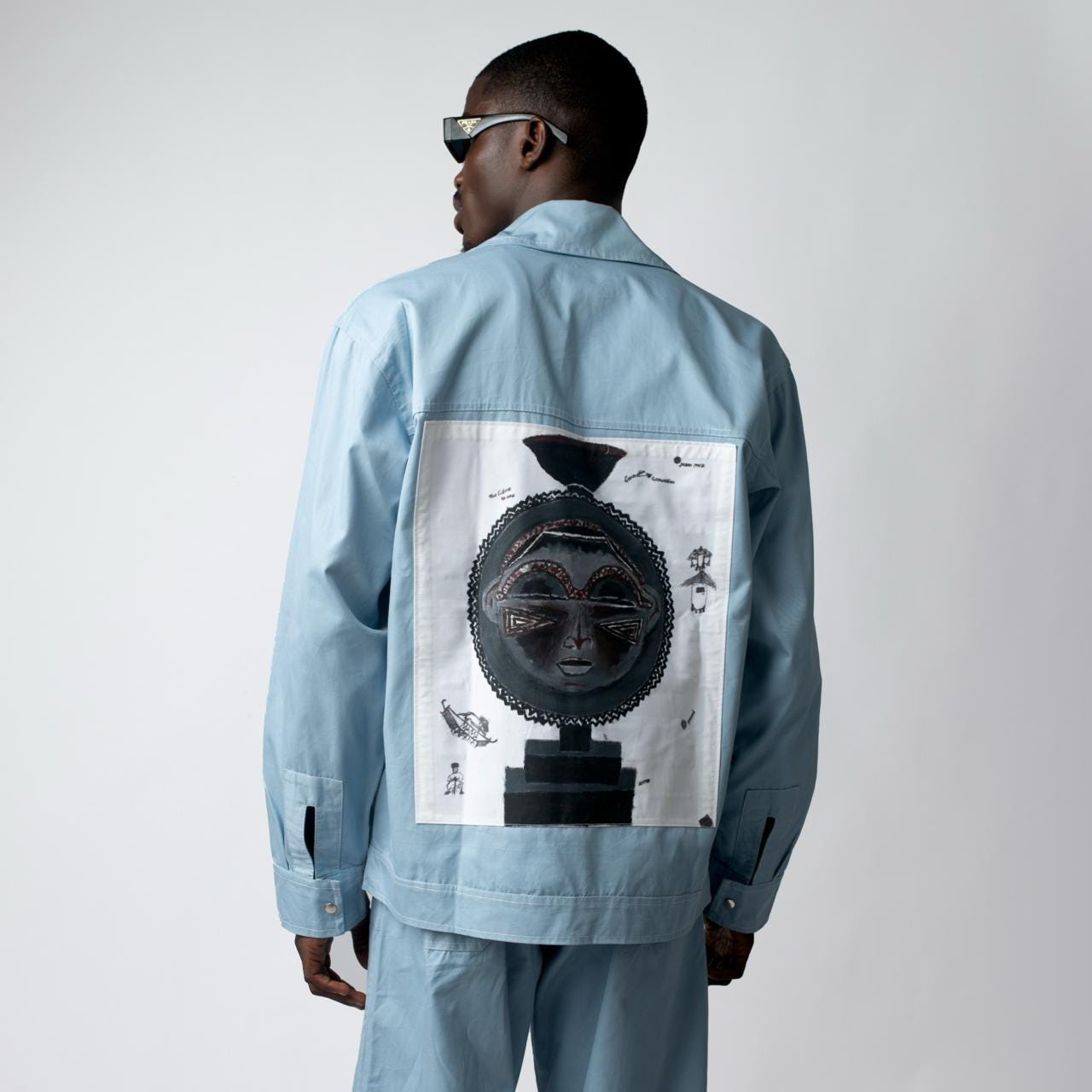 A model in the powder-blue moon-mask Heritage jacket glances back over his shoulder in sunglasses A model in the powder-blue moon-mask Heritage jacket glances back over his shoulder in sunglasses