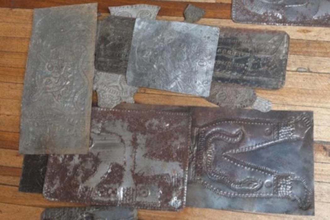 Carved metallic plates from Father Crespi’s collection of the Tayos Caves strewn on the floor in a dilapidated old building. Credit: Ancient-Origins.net