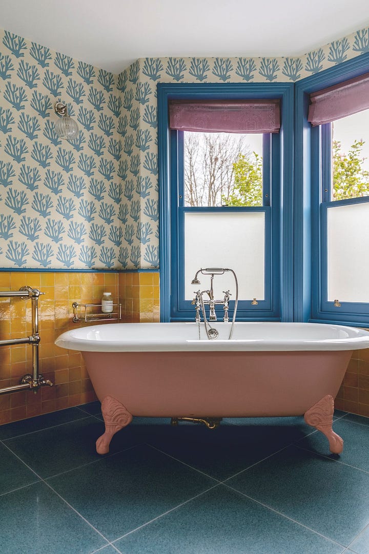 wooden kitchen cupboards, plywood, pendant glass light, wallpaper, yellow bathroom tiles, freestanding bath tub, chrome towel rail