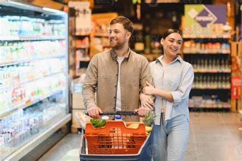 Happy young couple grocery shopping pushing cart 78814331 Stock Photo ...