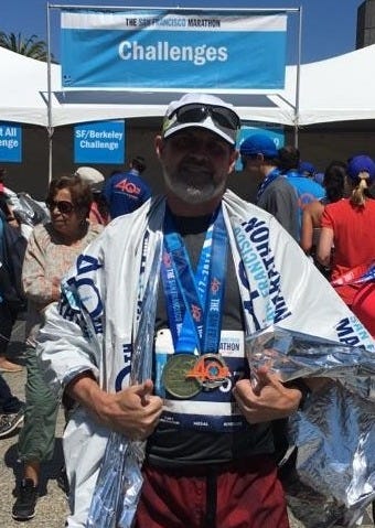 Merdhin after a marathon, smiling through exhaustion with medals.  A personal reminder that perseverance and awareness make completion possible.
