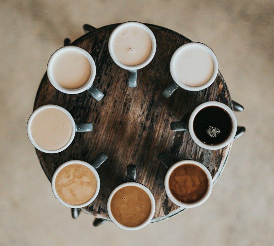 flat lay photography of eight coffee latte in mugs on round table flat lay photography of eight coffee latte in mugs on round table