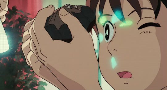 A girl peering into a small geode, the emeralds shining on her face.
