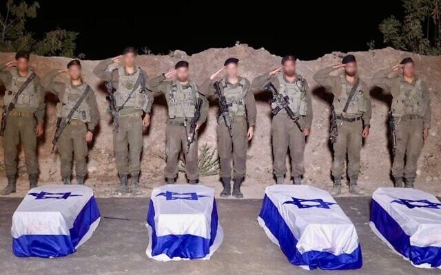 IDF troops salute over the caskets containing the bodies of slain hostages Guy Illouz, Bipin Joshi, Yossi Sharabi, and Daniel Perez in the Gaza Strip, late October 13, 2025. (Israel Defense Forces)
