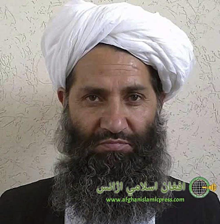 Bearded Haibatullah Akhundzada wearing a white head scarf. Bearded Haibatullah Akhundzada wearing a white head scarf.