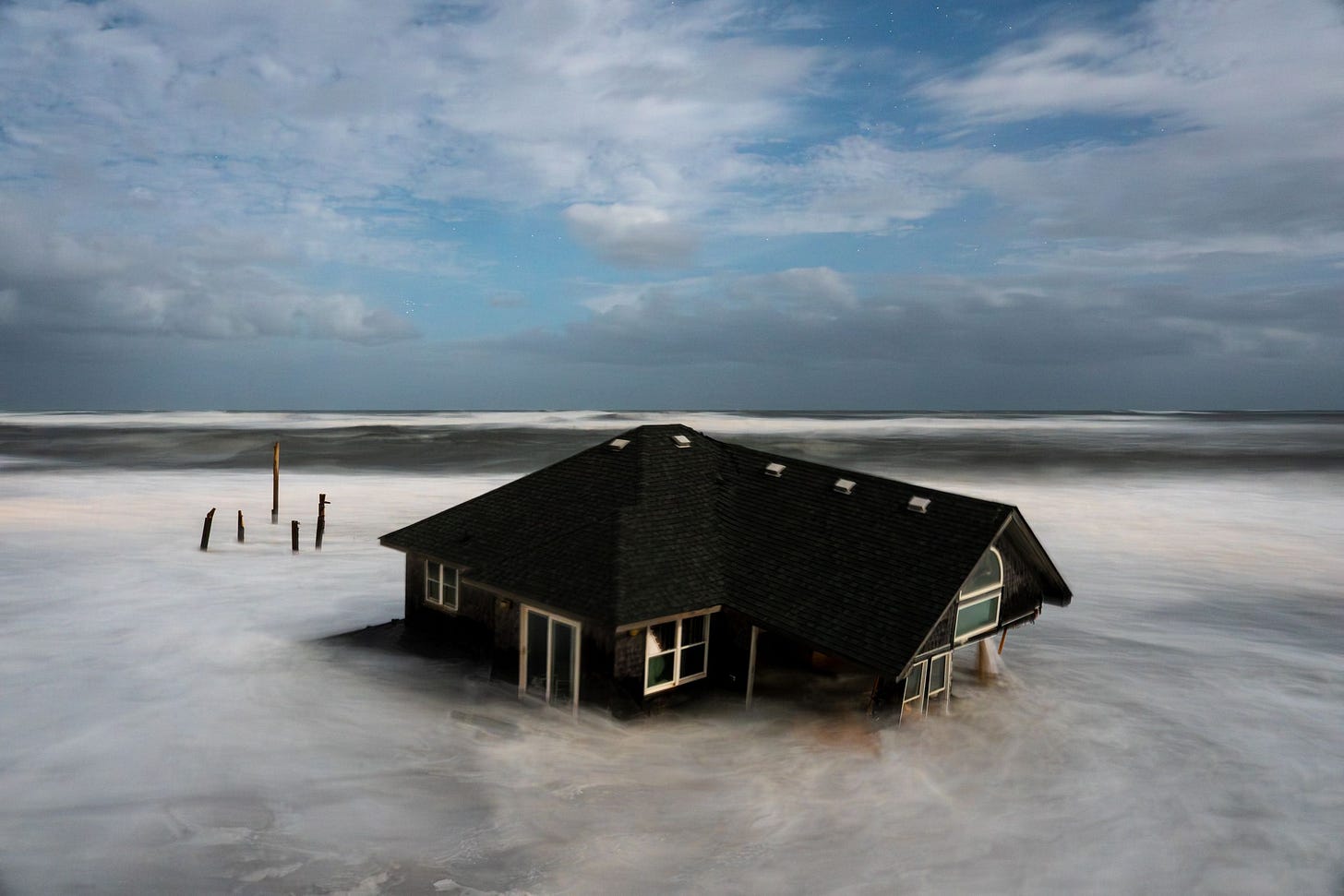 A longexposure photograph of a house surrounded by water.