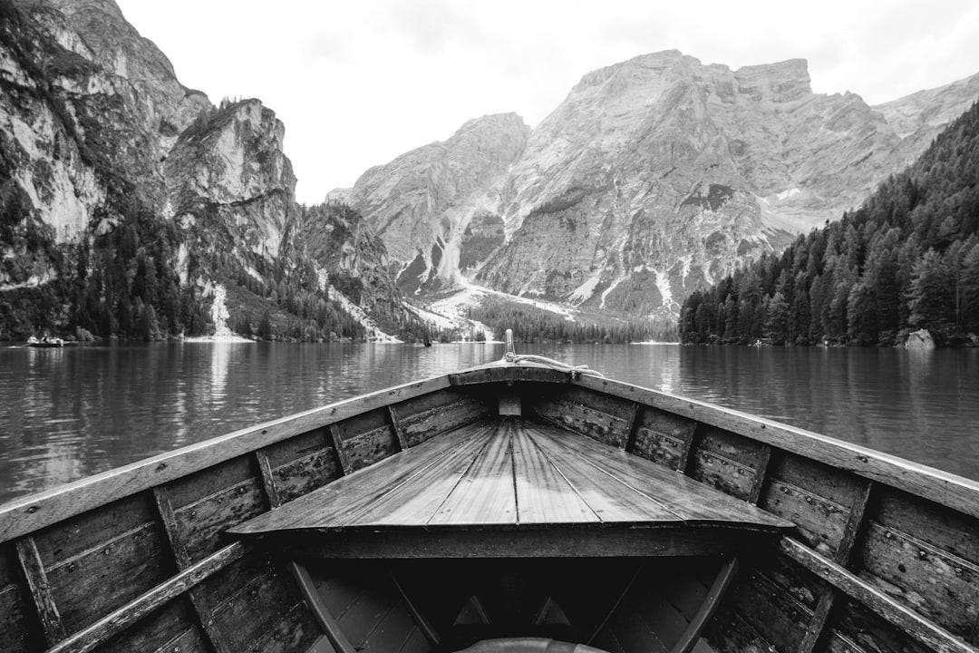 brown wooden boat moving towards the mountain brown wooden boat moving towards the mountain