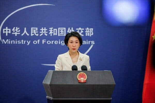 Mao Ning speaks from behind a lectern in front of a screen that contains Chinese characters and says, “Ministry of Foreign Affairs.”
