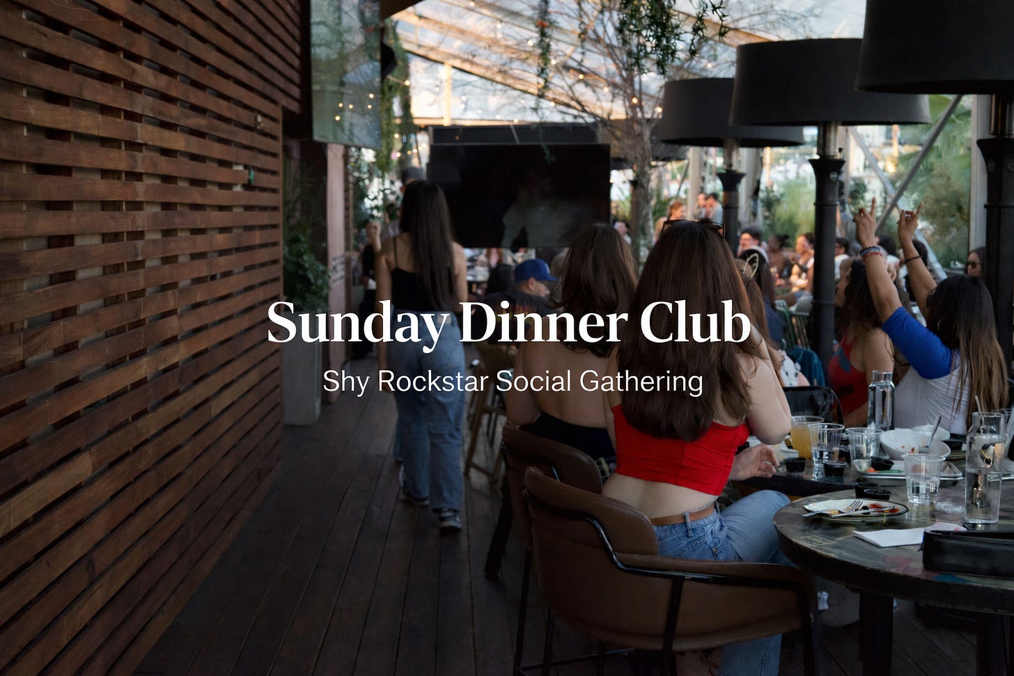Golden-hour patio dinner scene with guests seated at long tables beneath hanging greenery and outdoor heaters. A woman in a red top sits in the foreground as the centered text reads “Sunday Dinner Club” and “A Live Editorial Dining Experience. Golden-hour patio dinner scene with guests seated at long tables beneath hanging greenery and outdoor heaters. A woman in a red top sits in the foreground as the centered text reads “Sunday Dinner Club” and “A Live Editorial Dining Experience.