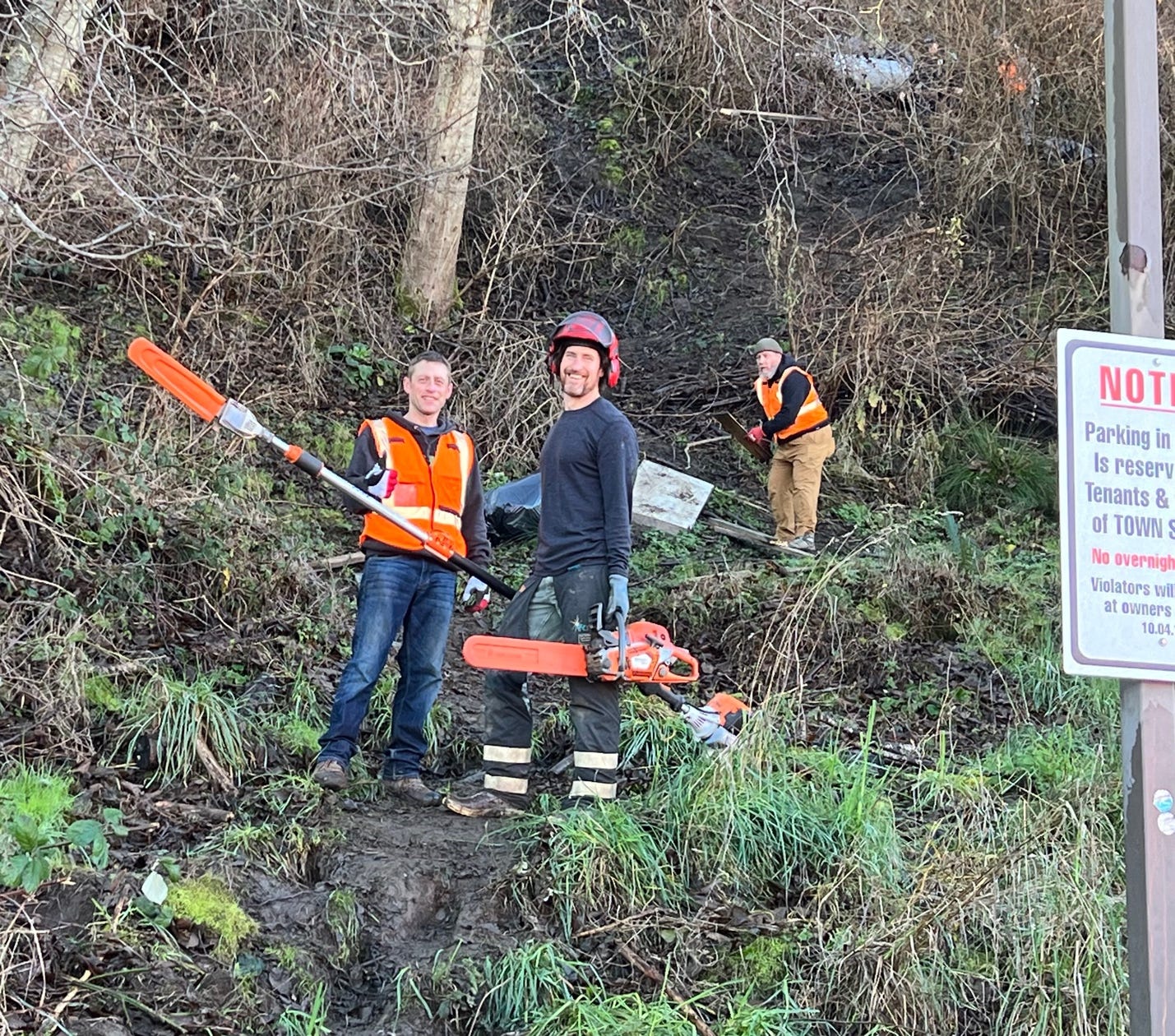 A group of men holding tools on a hill

Description automatically generated