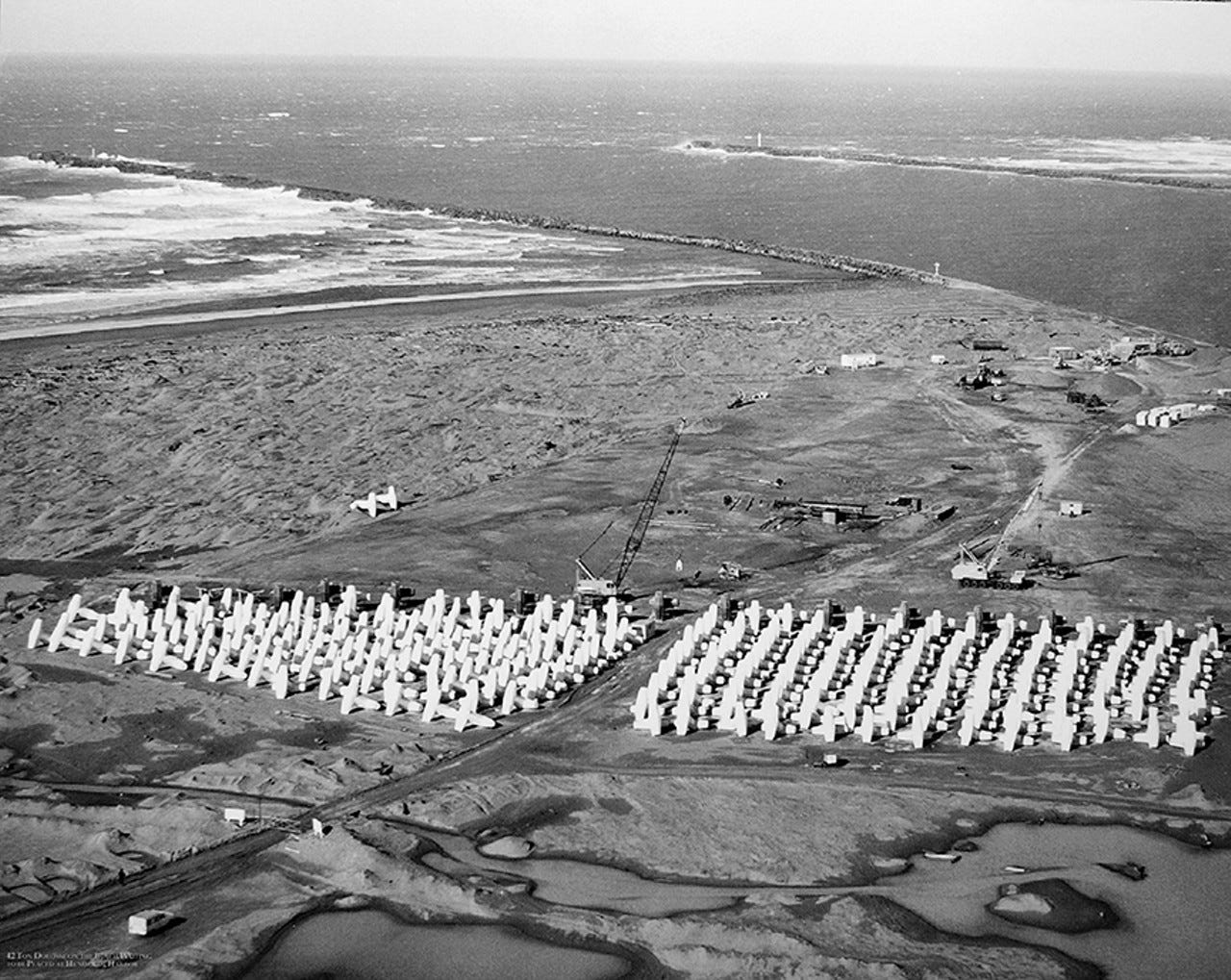 PHOTO COURTESY OF THE U.S. ARMY CORPS OF ENGINEERS - Thousands of dolosse were made in a casting yard on the south spit before being transported to the south and north jetties. PHOTO COURTESY OF THE U.S. ARMY CORPS OF ENGINEERS - Thousands of dolosse were made in a casting yard on the south spit before being transported to the south and north jetties.