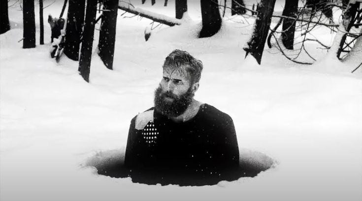 This may contain: a man with a beard sitting in the snow
