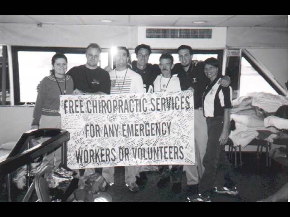 Black and white photo of seven volunteers holding a signed banner offering free chiropractic care to emergency workers
