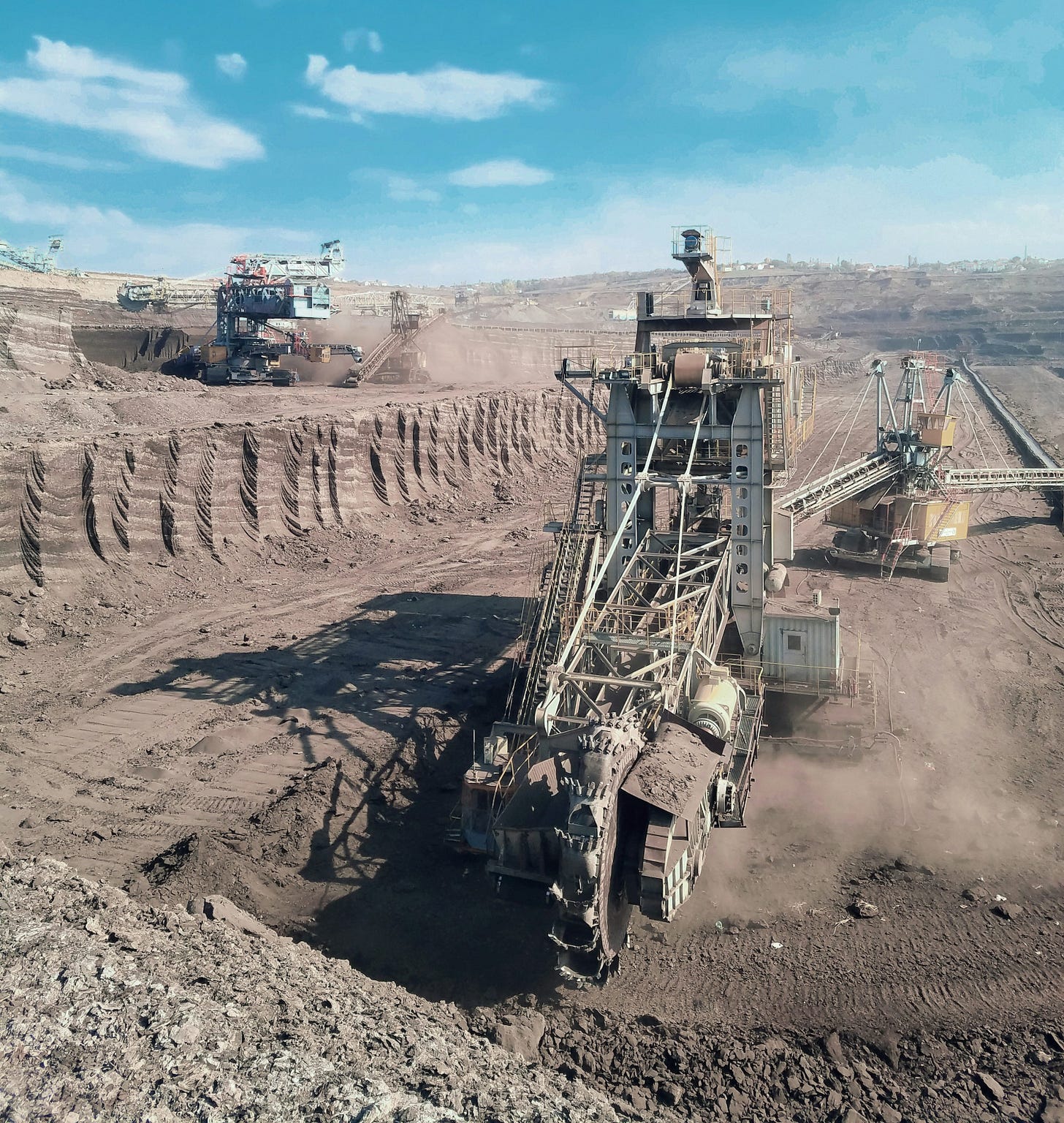 a large machine is in the middle of a dirt field a large machine is in the middle of a dirt field