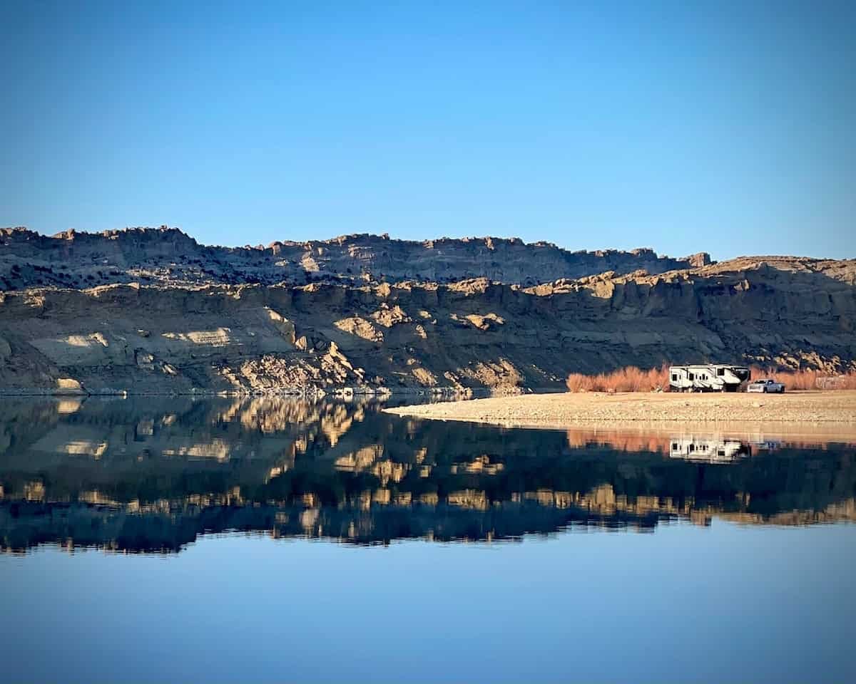 Lake and hillside, with an RV in the landscape. Lake and hillside, with an RV in the landscape.