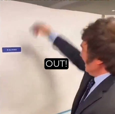 A person in a suit pointing at a white board

Description automatically generated