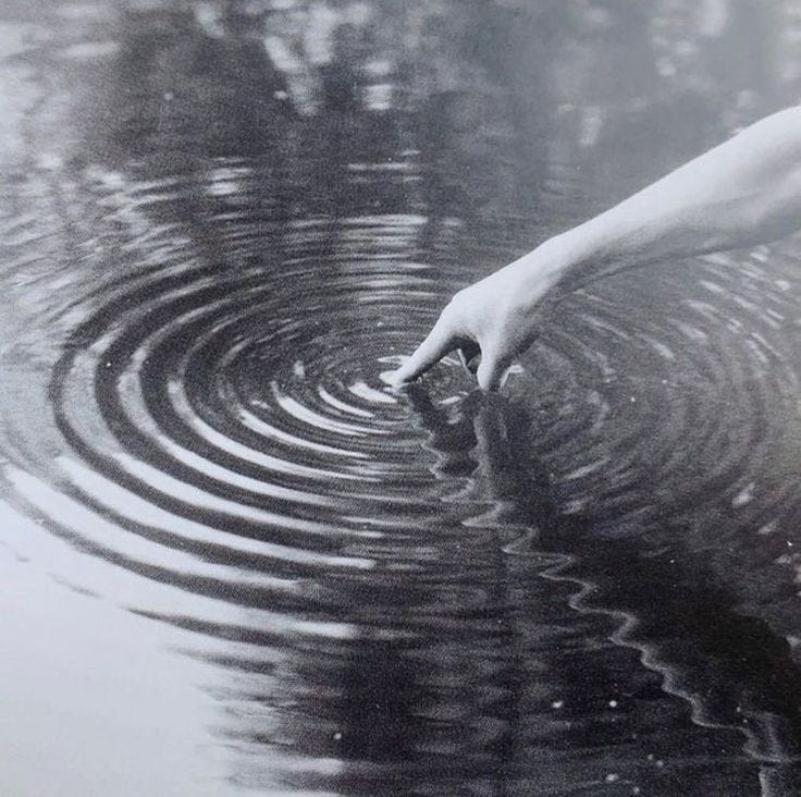 This may contain: a hand reaching for something in the water