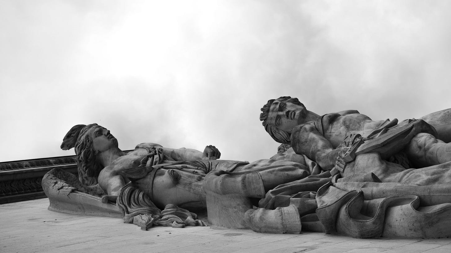 "Captivating vertical shot of marble statues under cloudy skies in Paris"