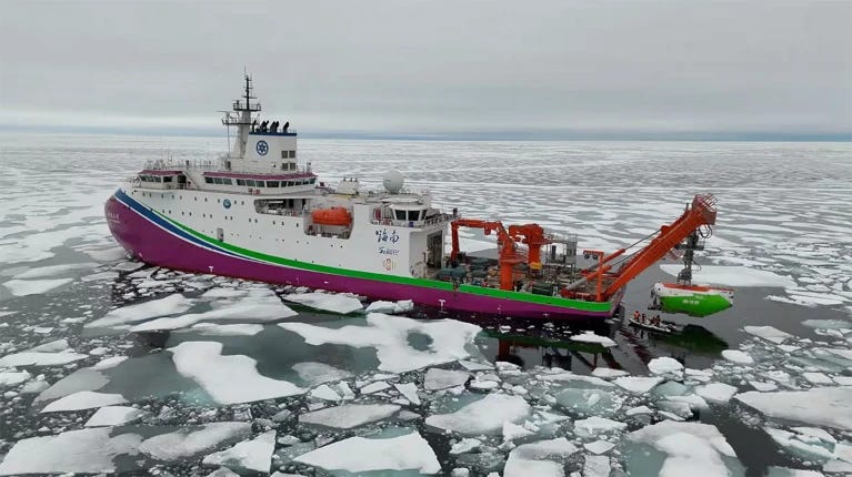 An elevated view of the Fendouzhe submersible (at right) going off the back of the icebreaker (at left) into a sea of broken ice.