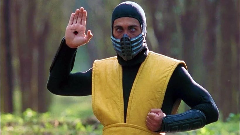 In the film adaptation of Mortal Kombat, Scorpion raises his hand. A hole has opened in his palm.
