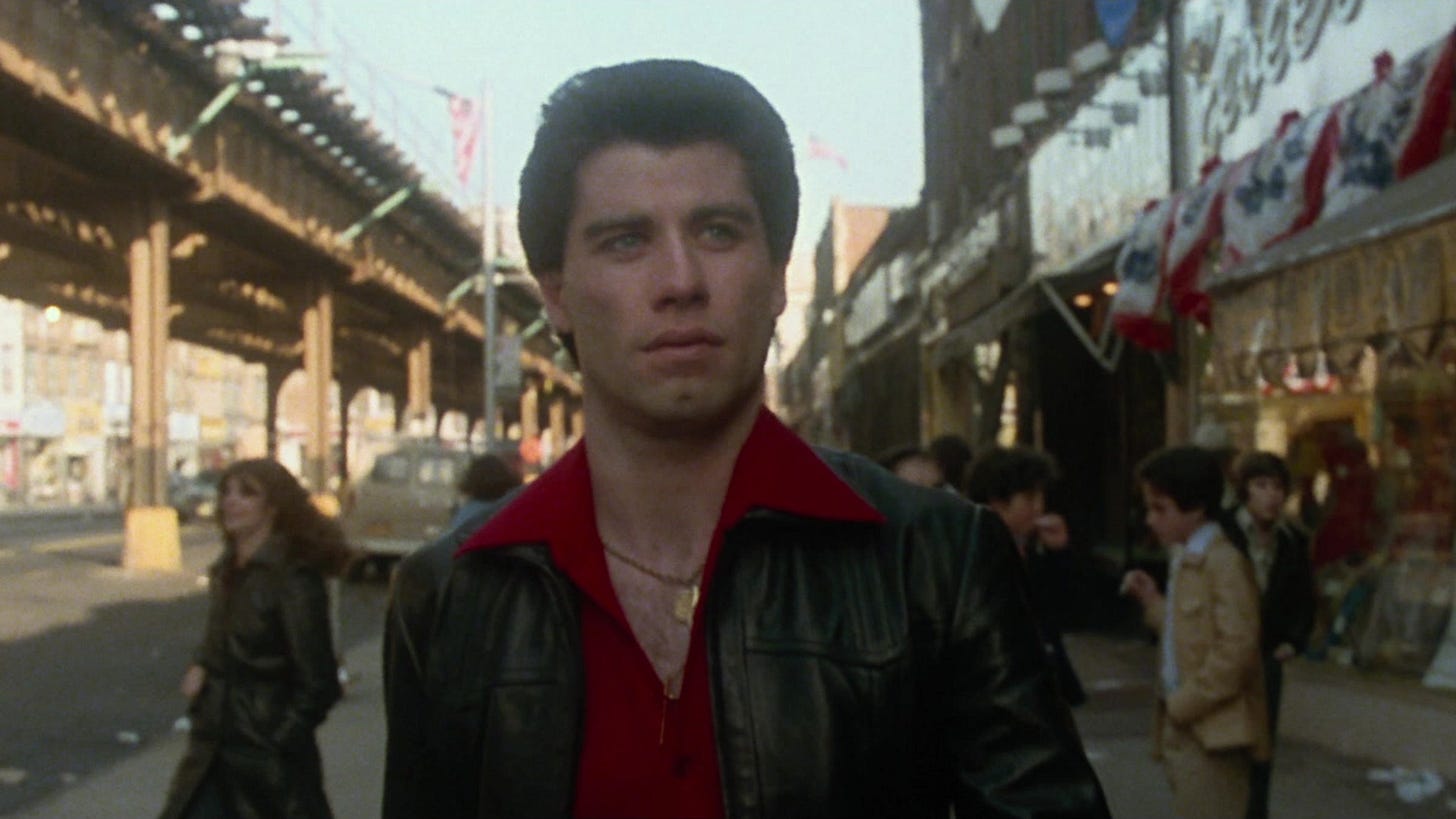 Tony Manero walking down 86th Street in Bay Ridge under the elevated line. Tony Manero walking down 86th Street in Bay Ridge under the elevated line.