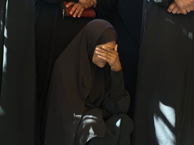 A woman clad in black mourns