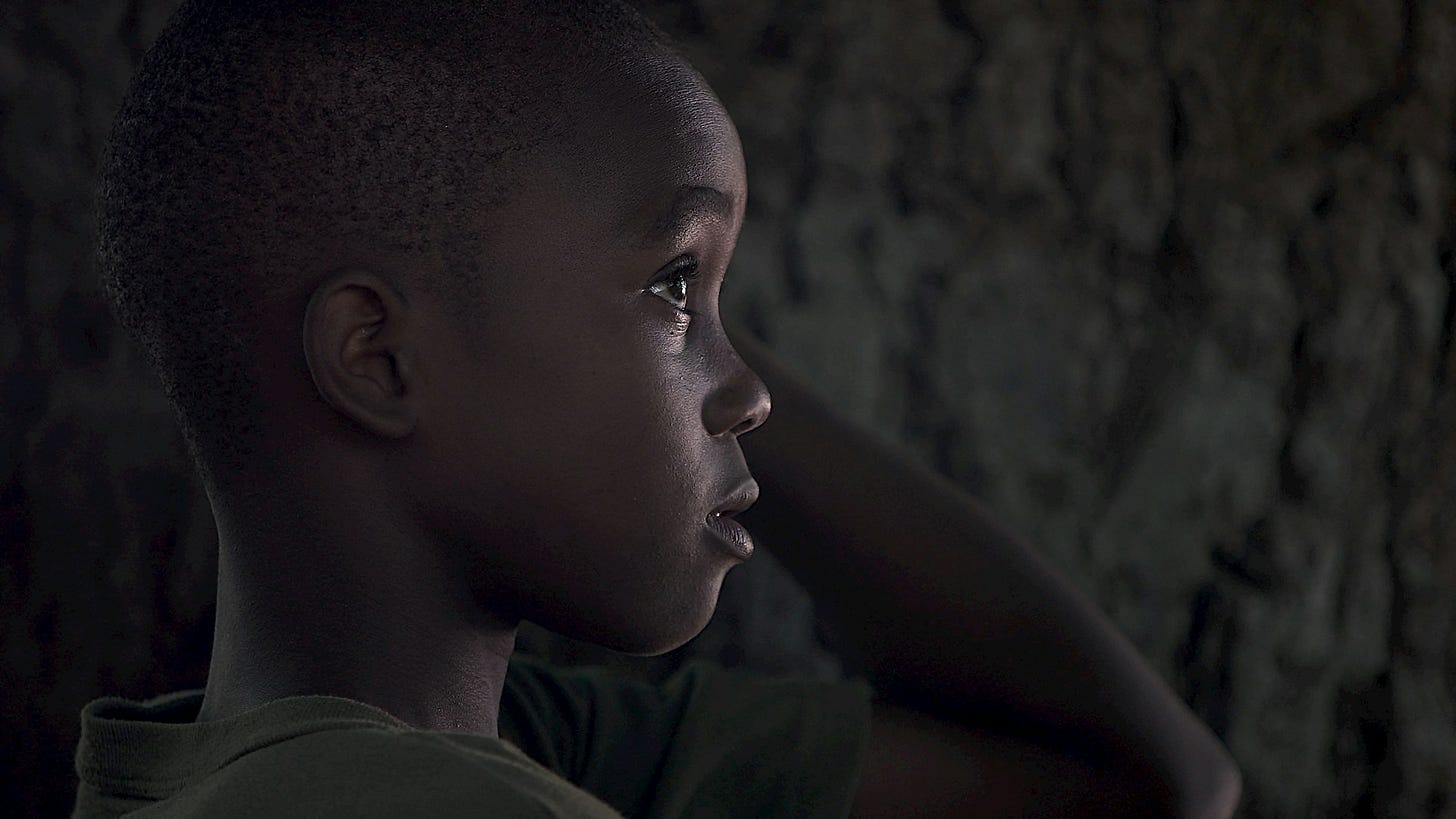 Photo of African American child in low light gazing upwards Photo of African American child in low light gazing upwards