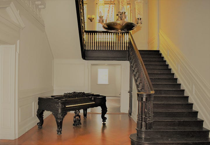 An old piano and beautiful wooden staircase at Laburnum.