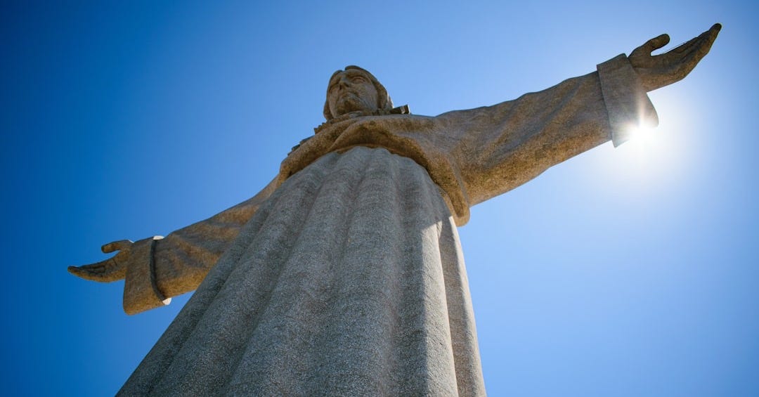 Christ the king statue is reaching towards the sky.