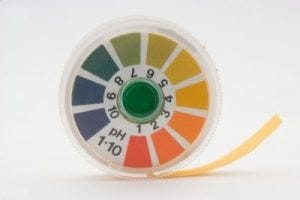a roll of pH test strips in a plastic container