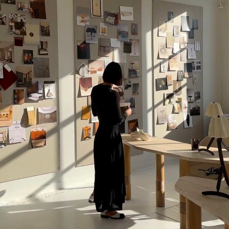 This may contain: a woman standing in an art gallery looking at artwork on the walls and floor, This may contain: a woman standing in an art gallery looking at artwork on the walls and floor,