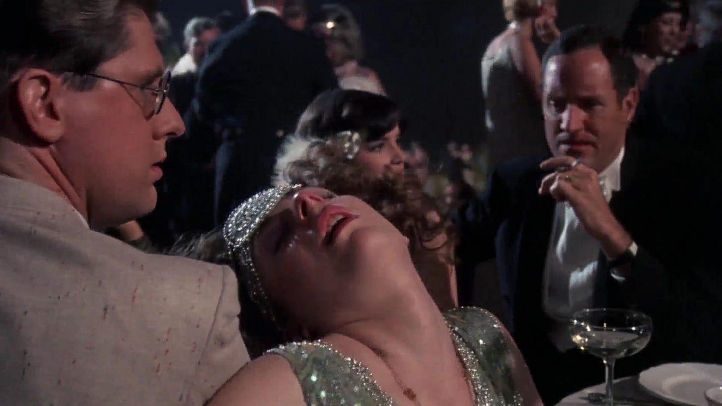 Two men look at a woman apparently swooning between them, all in period dress from the 1920s.