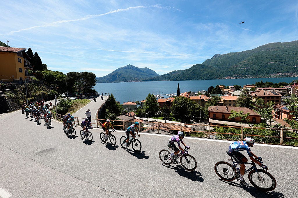 The pack rides past the town Bellano on the shore of Lake Como during the 18th stage of the 108th Giro d'Italia cycling race of 144kms from Morbegno to Cesano Maderno on May 29, 2025. (Photo by Luca Bettini / AFP)