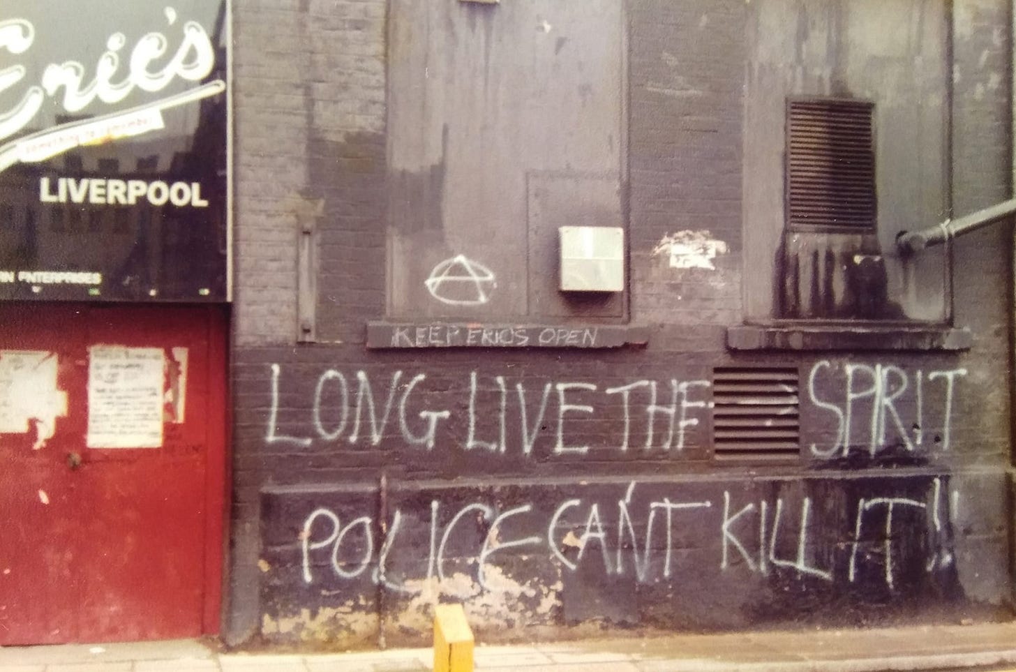 Outside the club, with graffiti on the wall reading “Long live the spirit – police can’t kill it.”