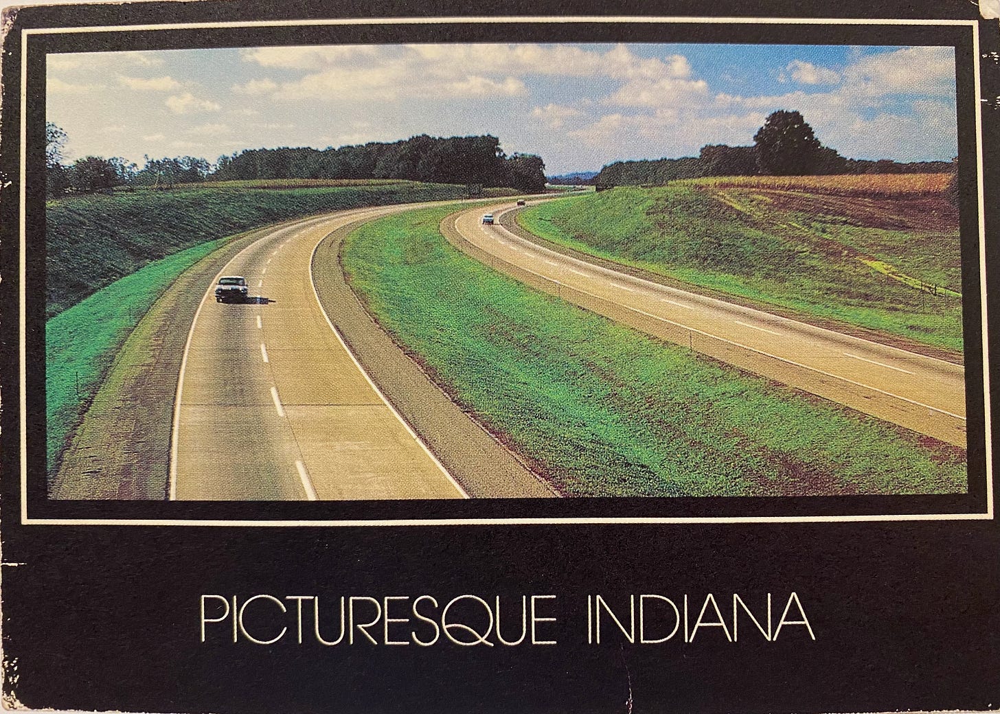 Vintage postcard of interstate highway in pastoral American landscape and text "PICTURESQUE INDIANA"