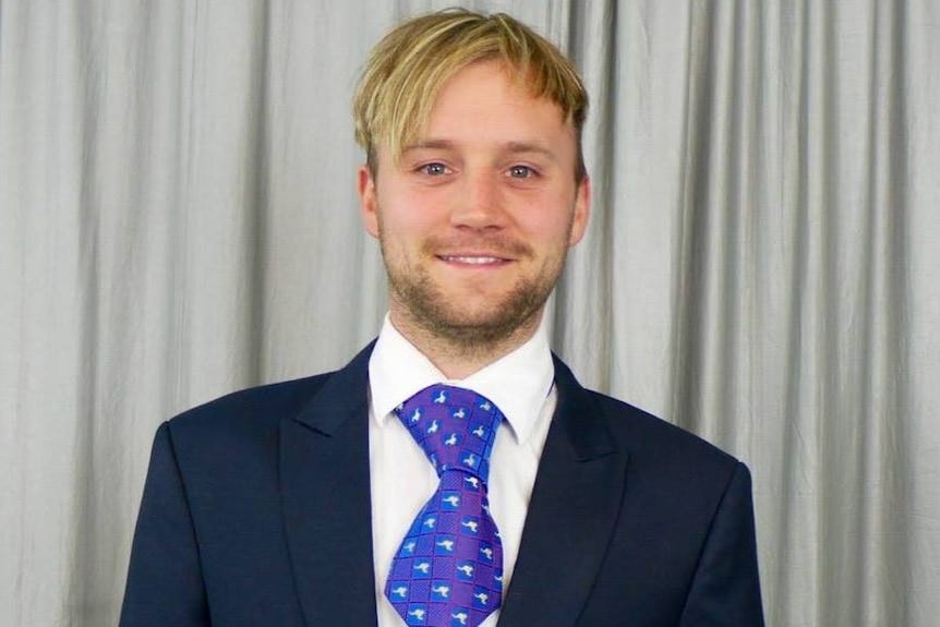 Andrew Nolch in a suit and short tie.