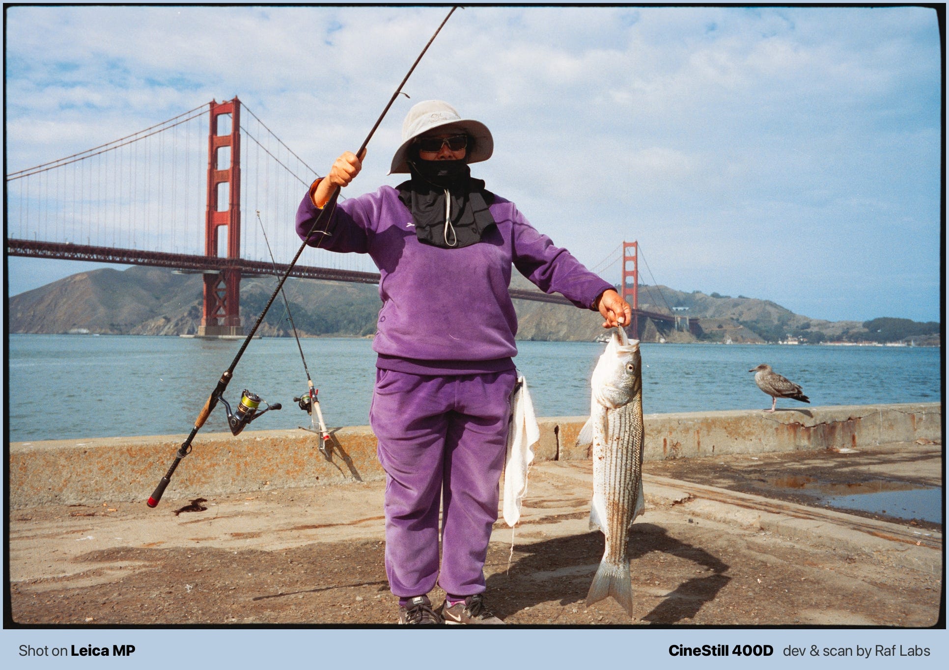 Photo of a woman holding a fish with the Golden Gate bridge behind