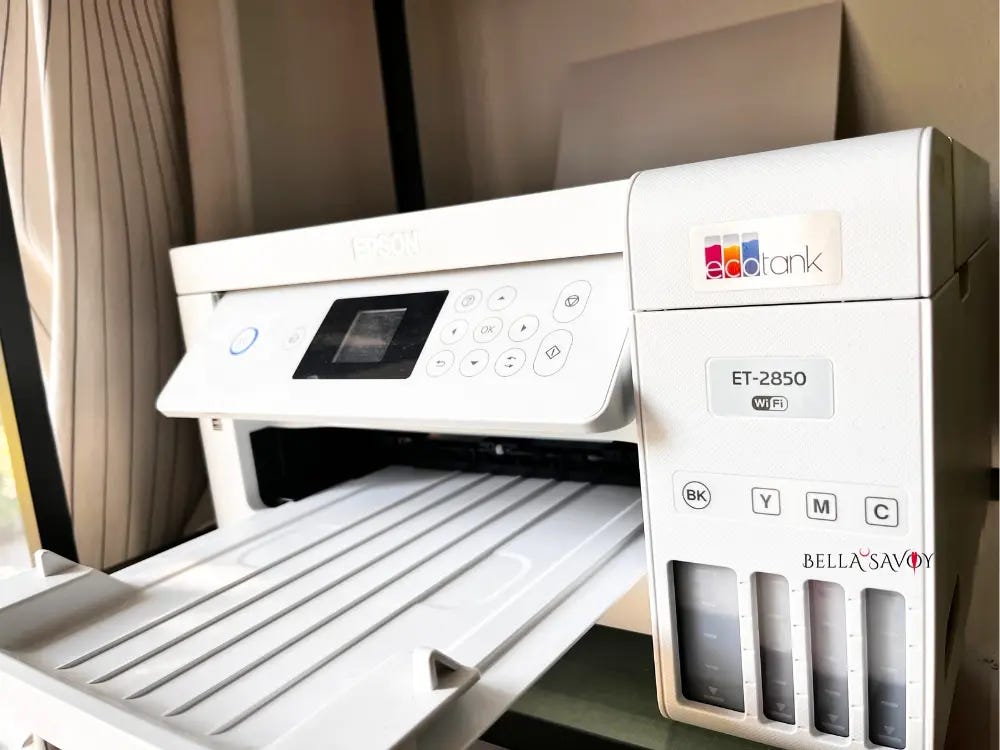 Epson ecotank printer on a glass shelf next to a window