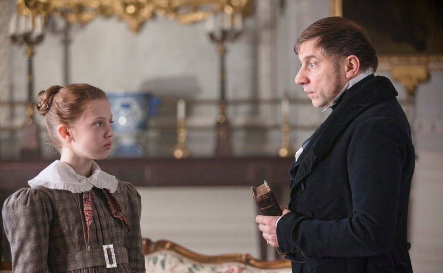a 10-year-old girl in a victorian dress frowning at a man dressed in a black suit holding a bible a 10-year-old girl in a victorian dress frowning at a man dressed in a black suit holding a bible